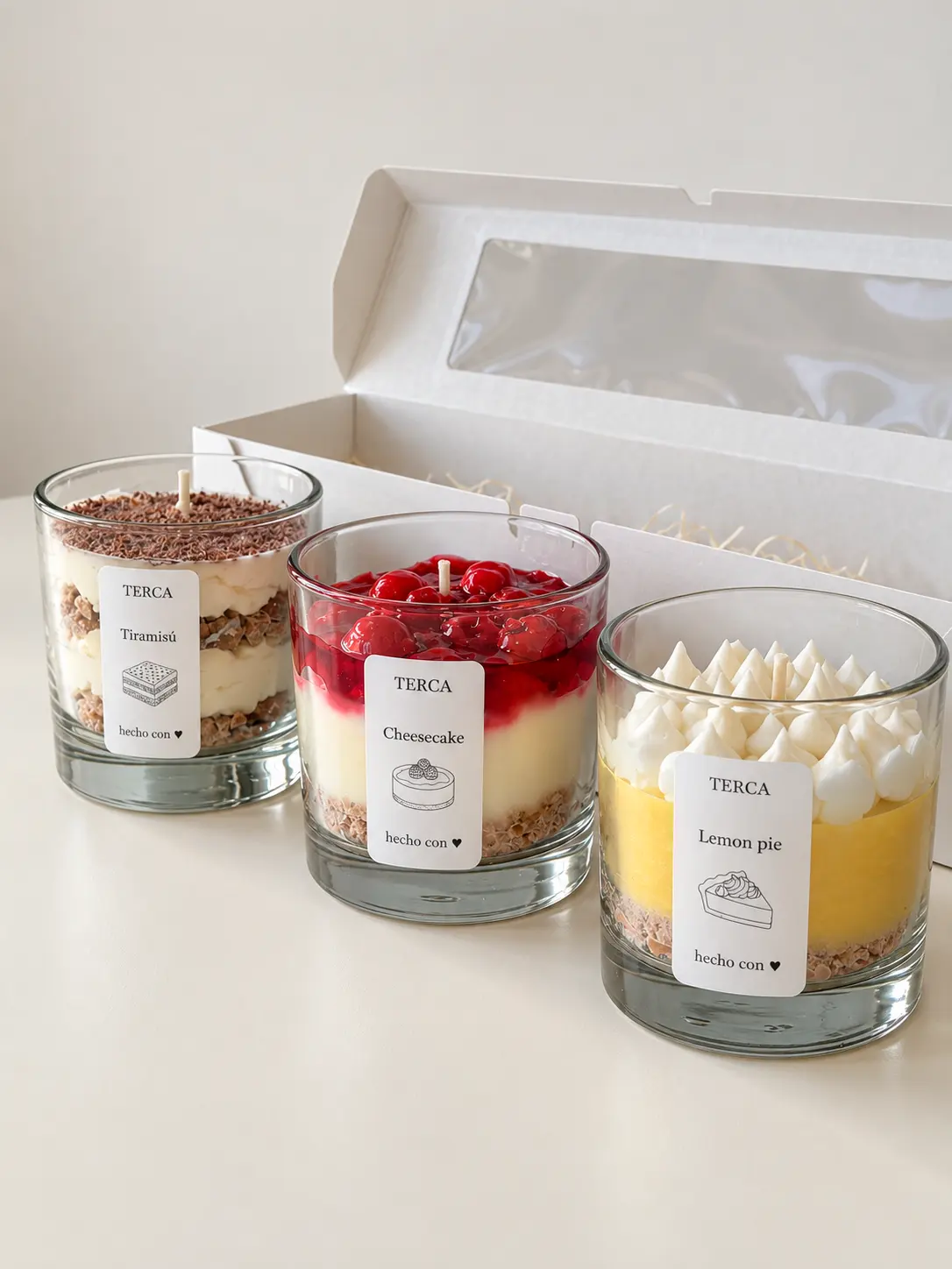 Las tres velas de la edición ANTOJO alineadas delante de su caja de regalo abierta
